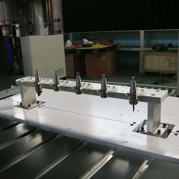 Close-up of a customized 4-axis ATC CNC router with rotary axis and multiple tool holders in an industrial workshop.