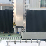 Close-up view of a customized small size 4 axis ATC CNC router with rotary axis and swing arm in a workshop setting.