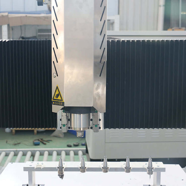 Close-up view of a customized small size 4 axis ATC CNC router with rotary axis and swing arm in a workshop setting.