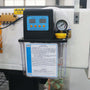 Oil lubrication system with digital control panel installed on machinery, featuring pressure gauge and instruction label.