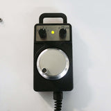 Handheld CNC router remote control with dial and buttons for precision adjustments.