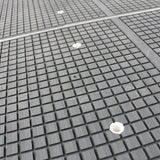 Close-up of a textured vacuum table surface on a CNC router machine for precise wood furniture processing.