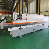 Precision automatic edge banding machine for furniture in a factory setting, showcasing advanced design and high-quality build.