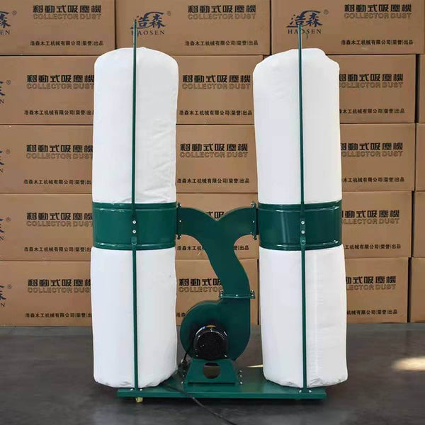 Industrial dust collector with dual filter bags, used for efficient dust removal in workshops. Green and white design.