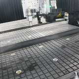 Industrial pressure roller machine in operation on a grid-patterned surface, highlighting precision engineering in manufacturing processes.