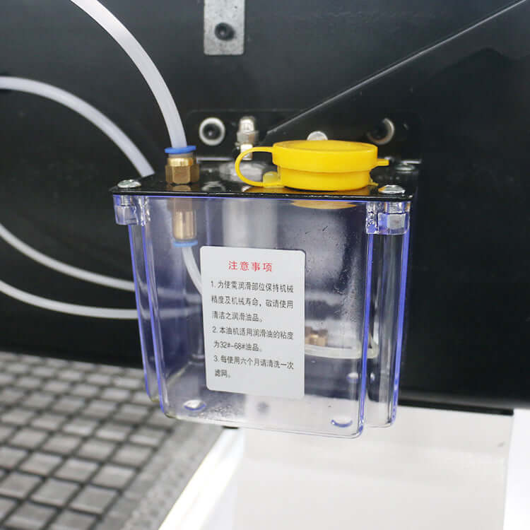 Close-up of an oil lubrication system with yellow cap and transparent container, showcasing mechanism and fluid lines.