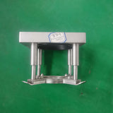 Metal platen press component on a green background.