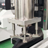 Close-up of a platen press component in a workshop setting, featuring metal parts and machinery elements.