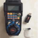 MACH 3 controller with display screen, colorful interface, USB dongle, and accessories for CNC machine operations on a white background.